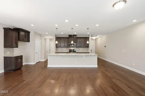 a large kitchen with stainless steel appliances kitchen island a large counter top and a stove top oven