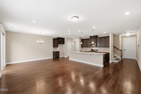 a view of kitchen with kitchen island a sink wooden floor and stainless steel appliances