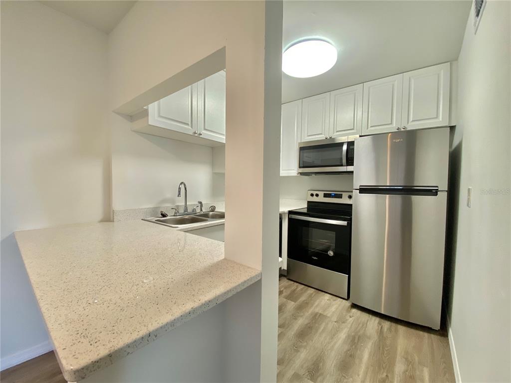 6519 West Newberry Road, Unit 1211 Gainesville, FL 32605 - Photo 6 of 10 a kitchen with a refrigerator and a sink
