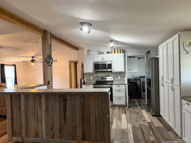 a kitchen with stainless steel appliances a refrigerator and a stove top oven