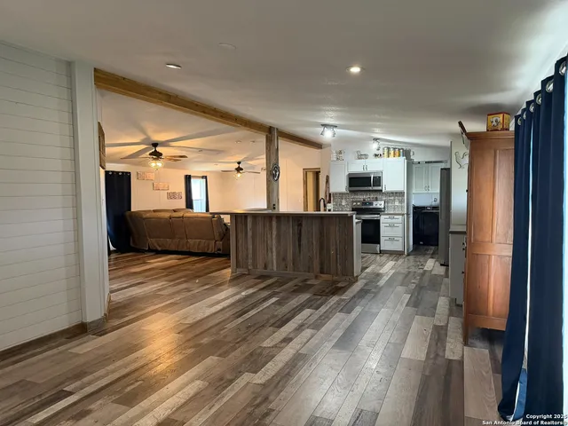 a view of a kitchen with furniture and a refrigerator