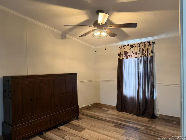 a view of a hallway with wooden floor and chandelier