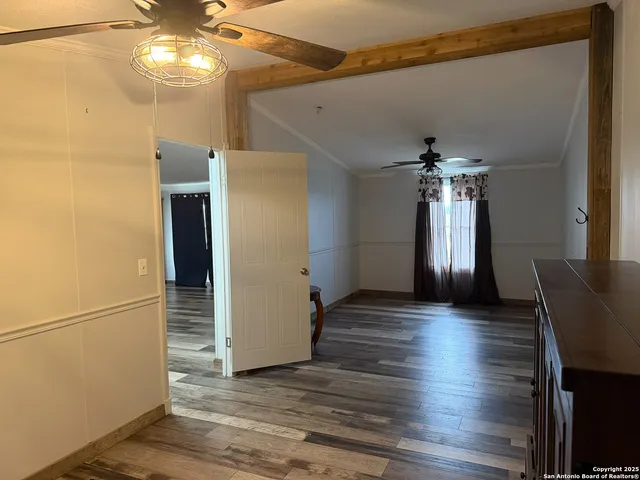 a view of a livingroom with wooden floor and a ceiling fan