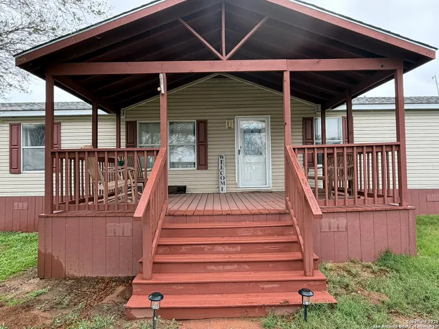 a view of a deck with wooden floor and roof with a small yard