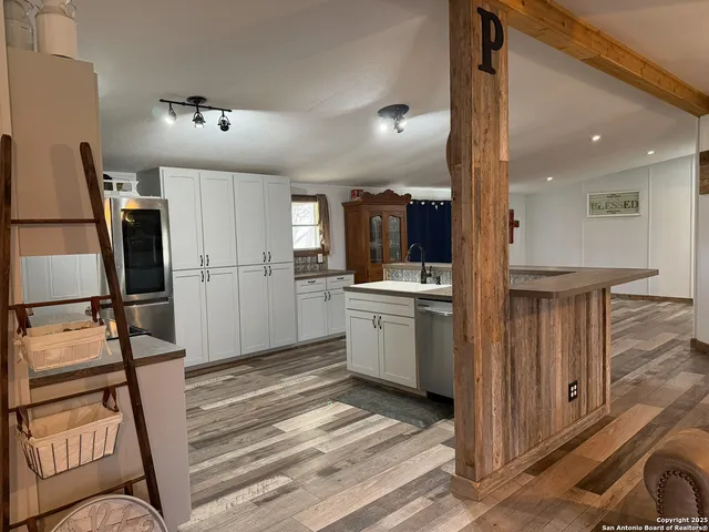 a kitchen with sink refrigerator and microwave