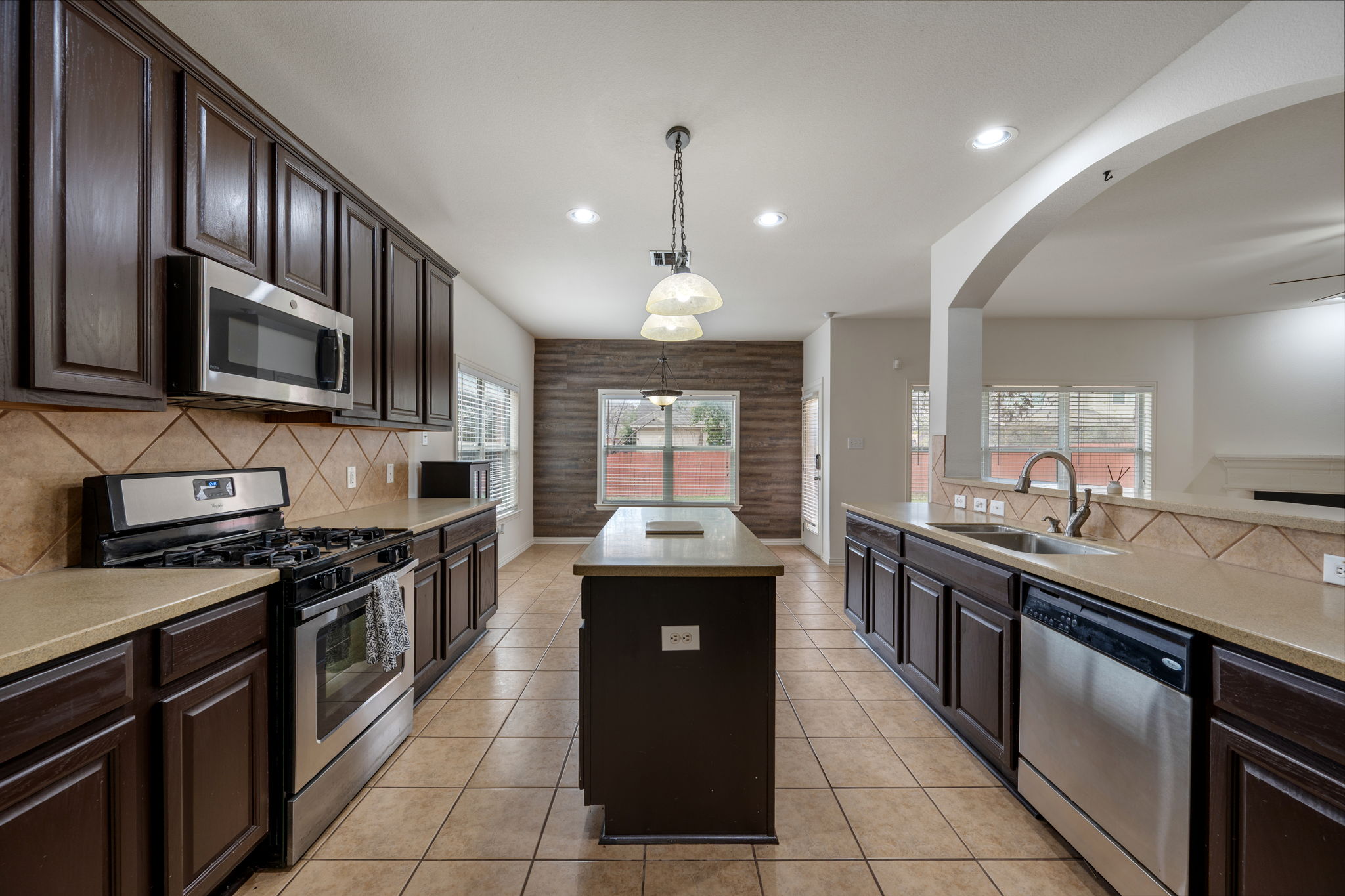 2415 Elkhorn Ranch Road Leander, TX 78641 - Photo 10 of 39 a kitchen with stainless steel appliances granite countertop a stove top oven a sink dishwasher a dining table and chairs