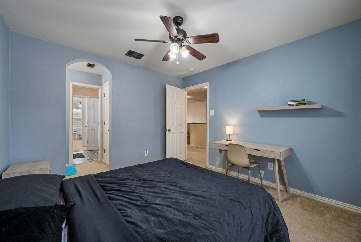 2415 Elkhorn Ranch Road Leander, TX 78641 - Photo 22 of 39 a bedroom with a bed and a chandelier