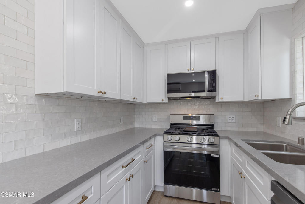 313 Raymond Street, Unit A Ojai, CA 93023 - Photo 7 of 32 a kitchen with granite countertop white cabinets and stainless steel appliances