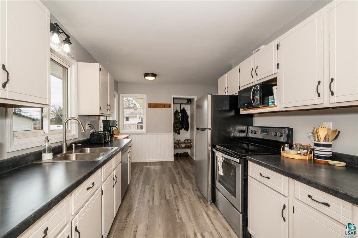 606 Maple Bend Drive Duluth, MN 55811 - Photo 5 of 30 Kitchen featuring white cabinets, dark countertops, appliances with stainless steel finishes, and a sink