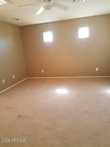 an empty room with a window and a fan