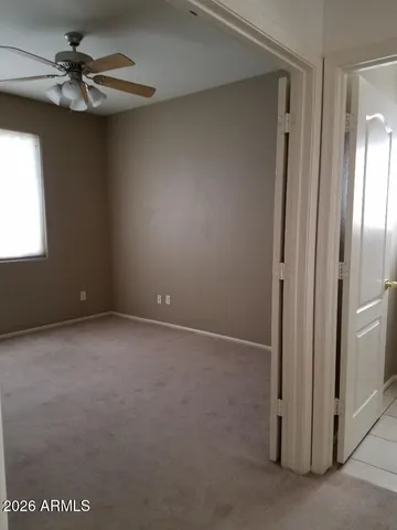 an empty room with a ceiling fan and a window