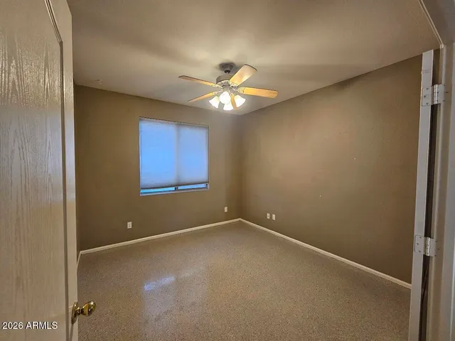 an empty room with closet and a chandelier fan
