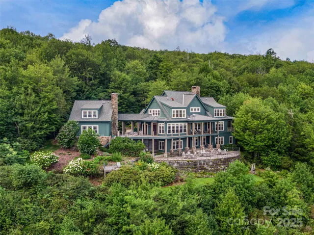 aerial view of a house with a big yard and large trees