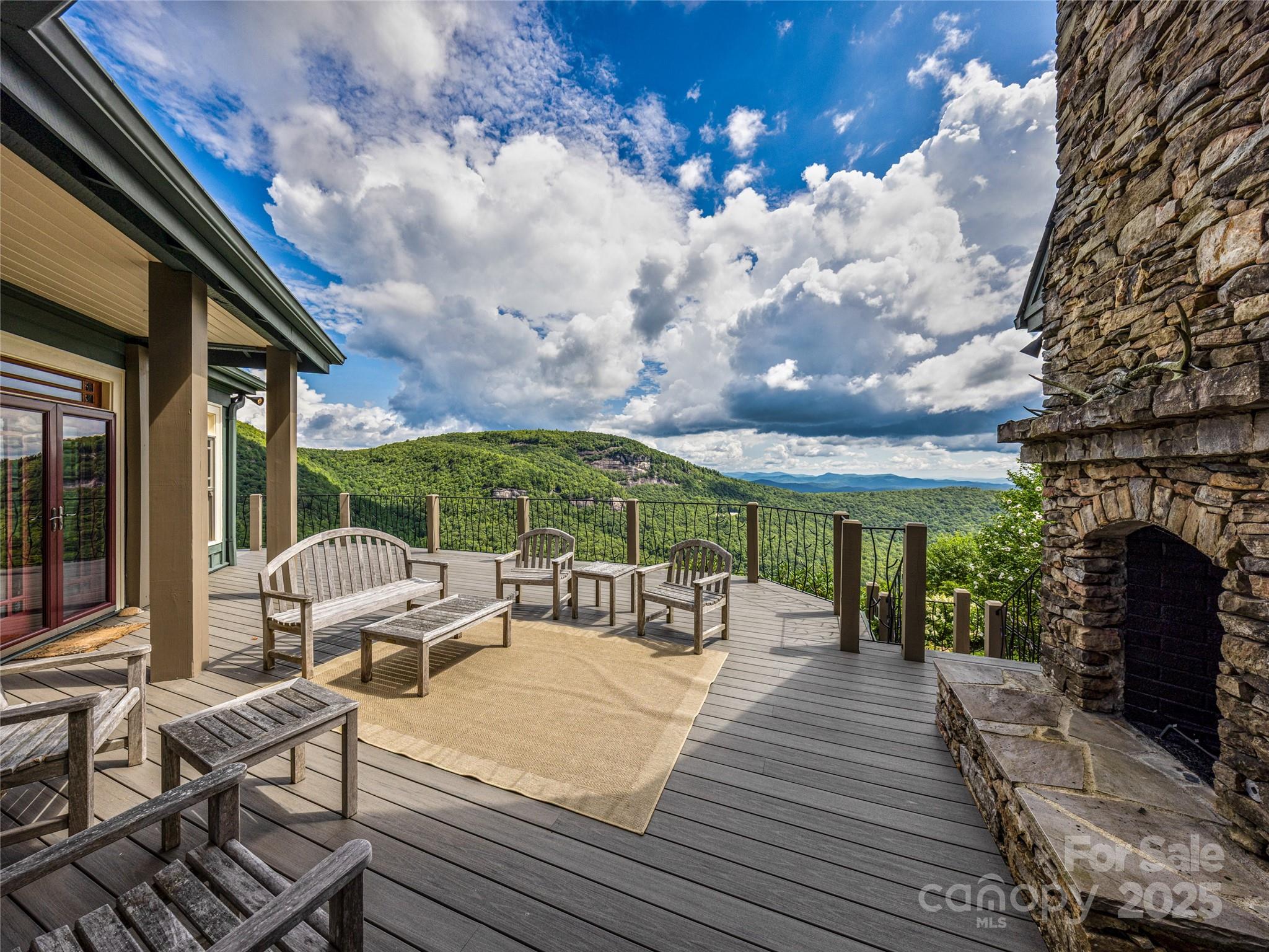 770 Mdw Rdg Drive Lake Toxaway, NC 28747 - Photo 46 of 48 a view of a patio with table and chairs potted plants and floor to ceiling window