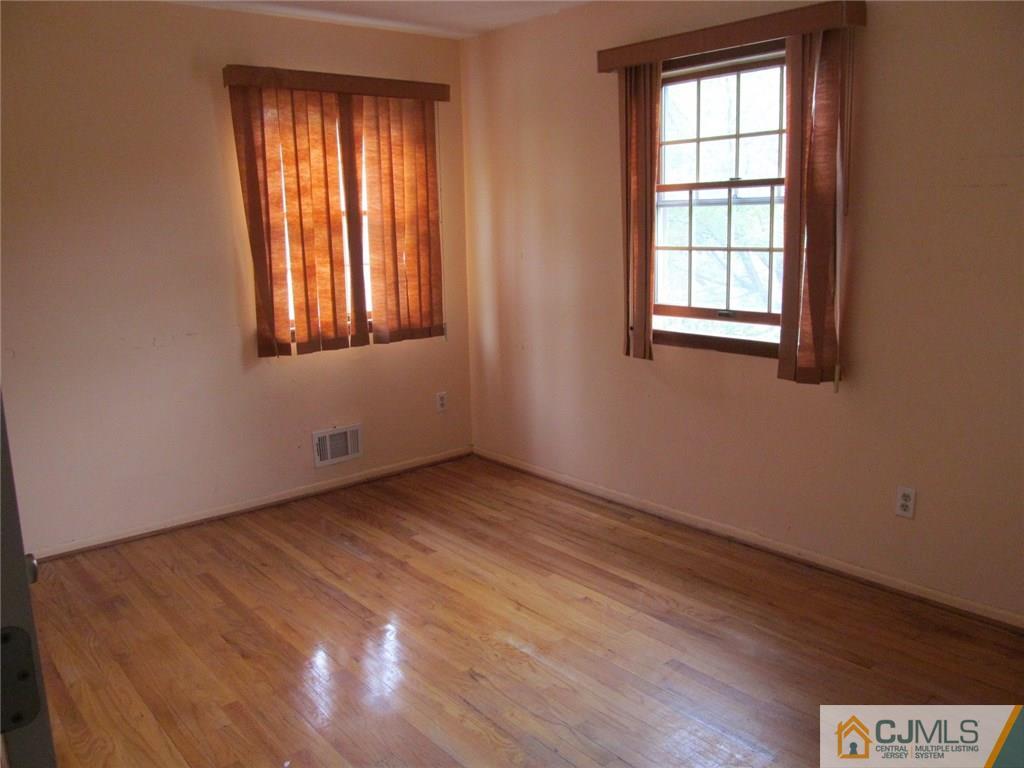 12 Kings Road East Brunswick, NJ 08816 - Photo 12 of 24 an empty room with wooden floor and windows