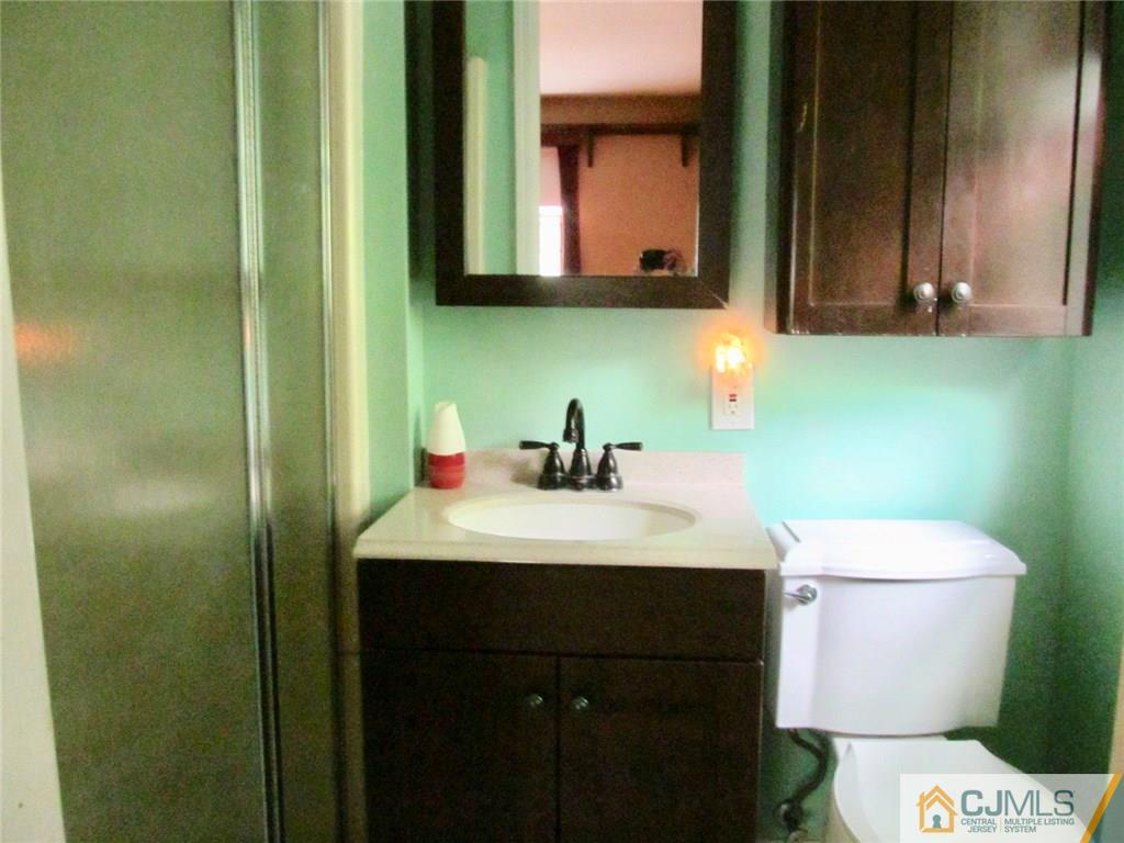 12 Kings Road East Brunswick, NJ 08816 - Photo 17 of 24 a bathroom with a sink a toilet and mirror