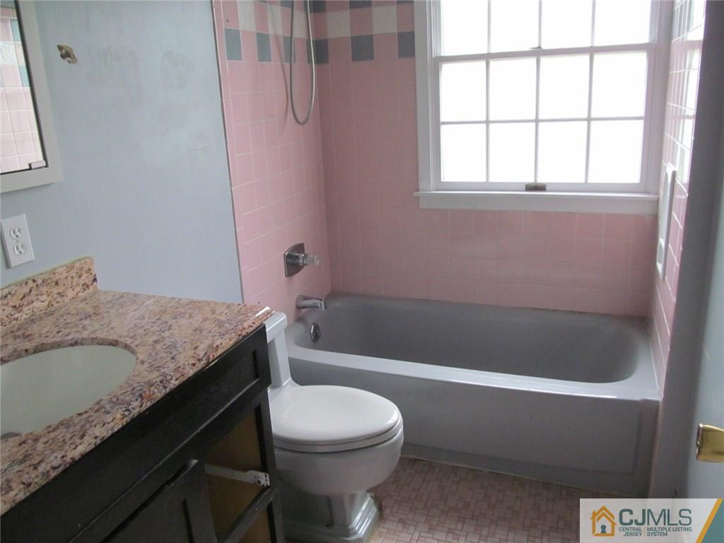 12 Kings Road East Brunswick, NJ 08816 - Photo 18 of 24 a bathroom with a granite countertop bathtub sink vanity mirror and toilet