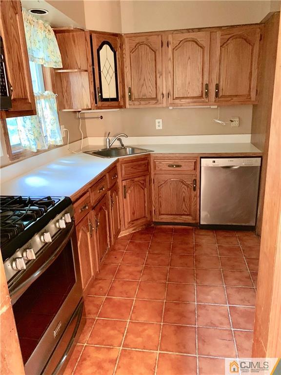 12 Kings Road East Brunswick, NJ 08816 - Photo 6 of 24 a kitchen with stainless steel appliances granite countertop a sink stove and cabinets