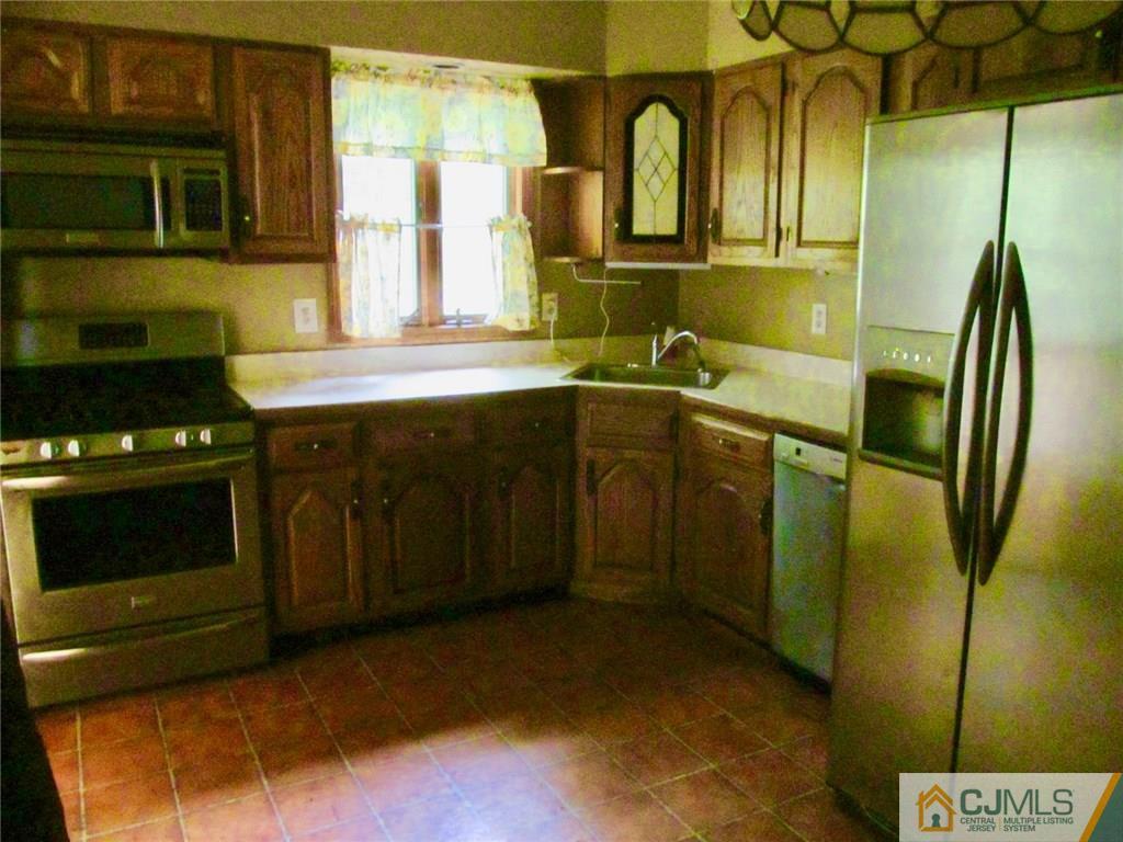 12 Kings Road East Brunswick, NJ 08816 - Photo 7 of 24 a kitchen with stainless steel appliances granite countertop a stove a sink and a microwave