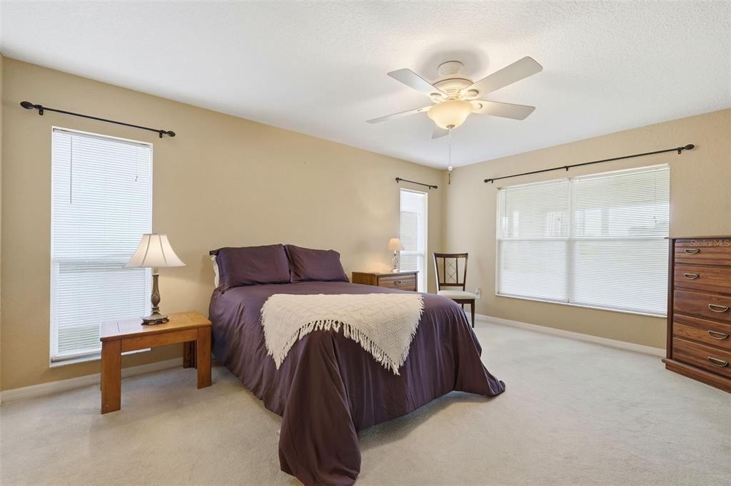 17083 Southeast 115th Terrace Road Summerfield, FL 34491 - Photo 19 of 61 a spacious bedroom with a bed and a chandelier