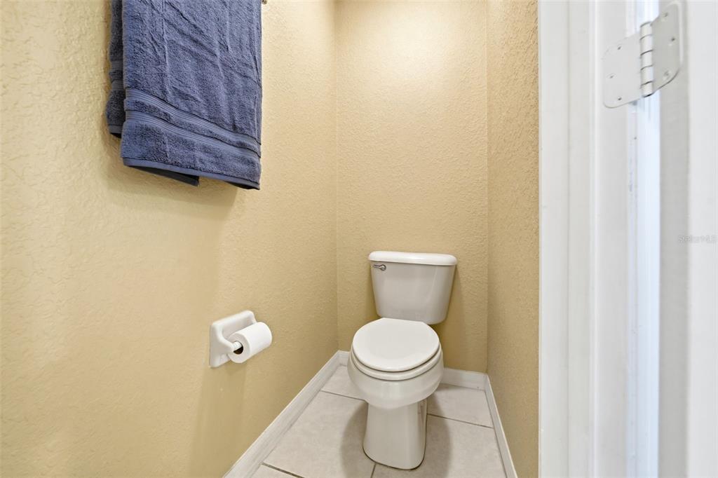 17083 Southeast 115th Terrace Road Summerfield, FL 34491 - Photo 27 of 61 a white toilet sitting next to a wooden cabinet