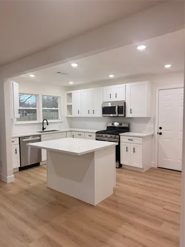 a large kitchen with stainless steel appliances and a sink