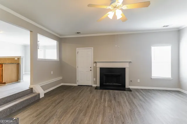 an empty room with windows and fireplace
