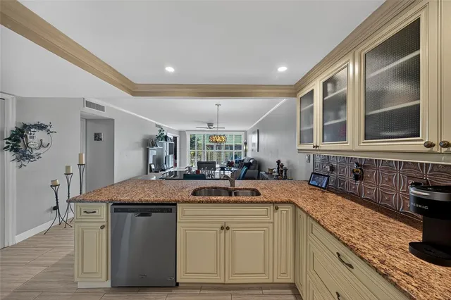 a kitchen with granite countertop a sink and cabinets