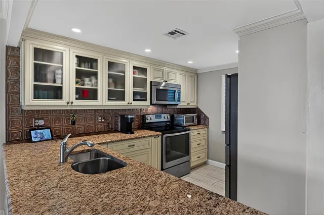 a kitchen with stainless steel appliances granite countertop a sink stove and refrigerator