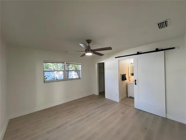 an empty room with a window and a ceiling fan