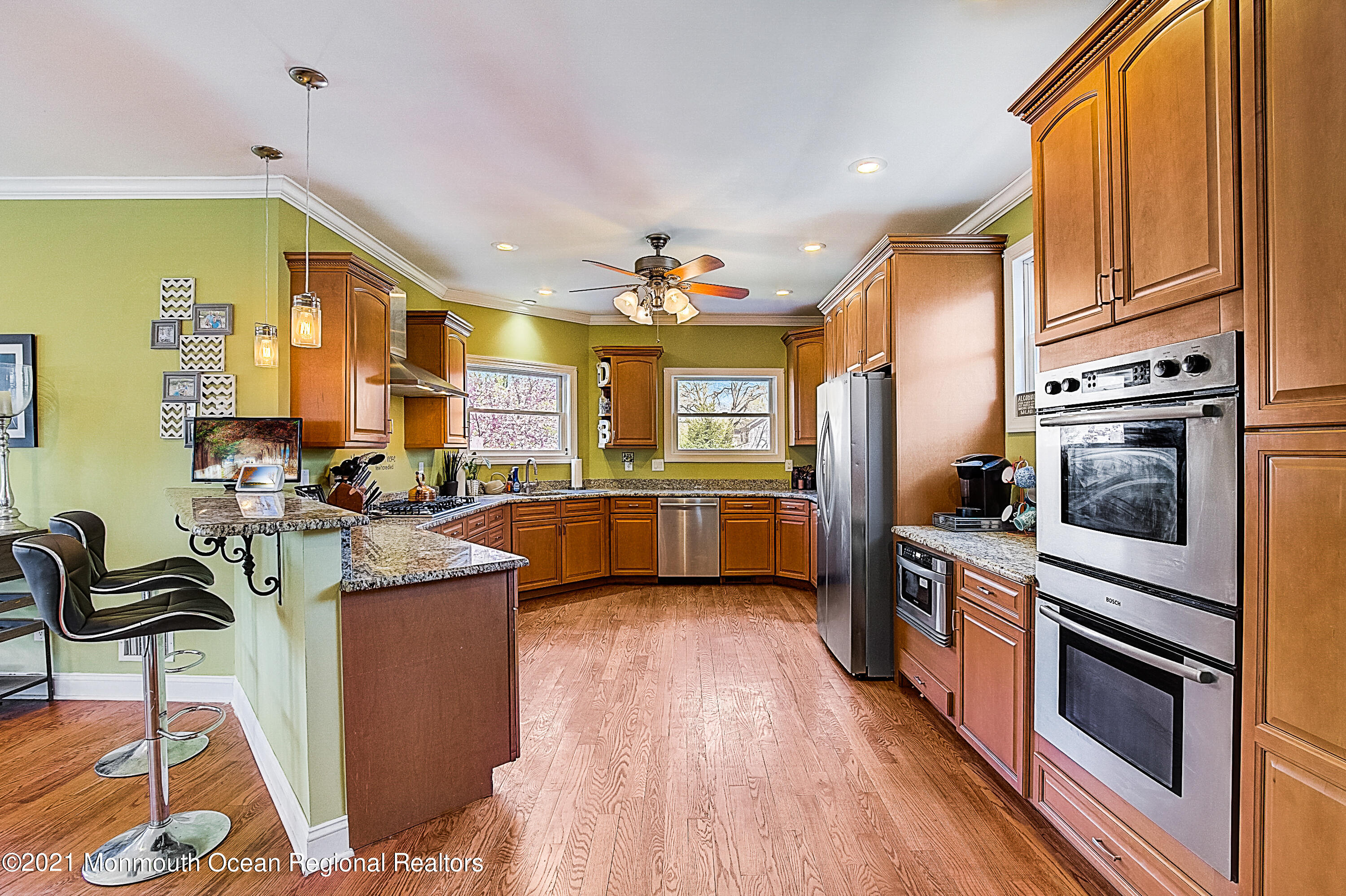 286 Main Street Middletown, NJ 07758 - Photo 19 of 69 a kitchen with stainless steel appliances kitchen island granite countertop a stove top oven a sink dishwasher a dining table and chairs with wooden floor