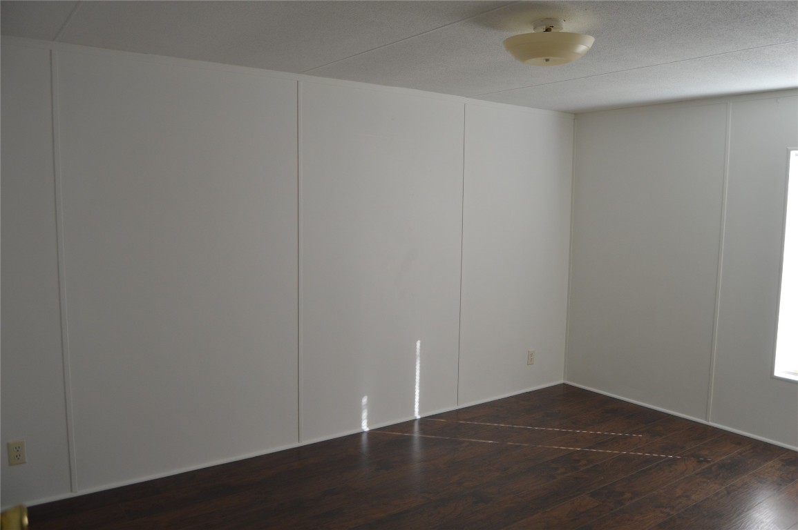 1406 East Wallisville Road Highlands, TX 77562 - Photo 5 of 26 an empty room with wooden floor and white walls