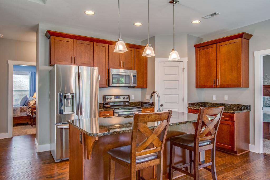 5012 Geranium Drive Spring Hill, TN 37174 - Photo 7 of 26 a kitchen with stainless steel appliances granite countertop a refrigerator a stove top oven a sink dishwasher and wooden floor