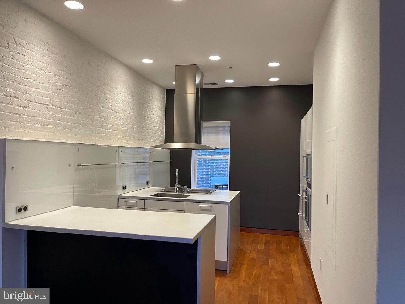 3336 Cady's Alley Northwest, Unit 201 Washington, DC 20007 - Photo 11 of 34 a kitchen with kitchen island a sink stainless steel appliances and cabinets