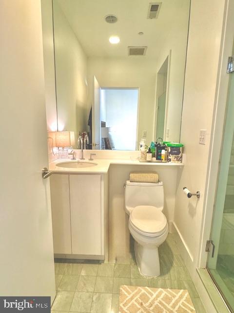 3336 Cady's Alley Northwest, Unit 201 Washington, DC 20007 - Photo 22 of 34 a bathroom with a granite countertop toilet a sink and a mirror