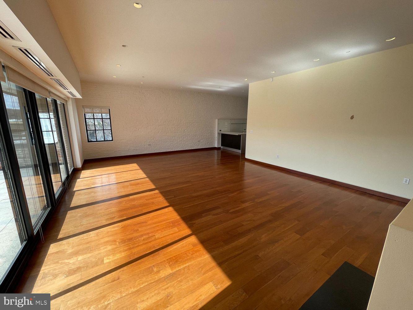 3336 Cady's Alley Northwest, Unit 201 Washington, DC 20007 - Photo 3 of 34 a view of an empty room with wooden floor and a window