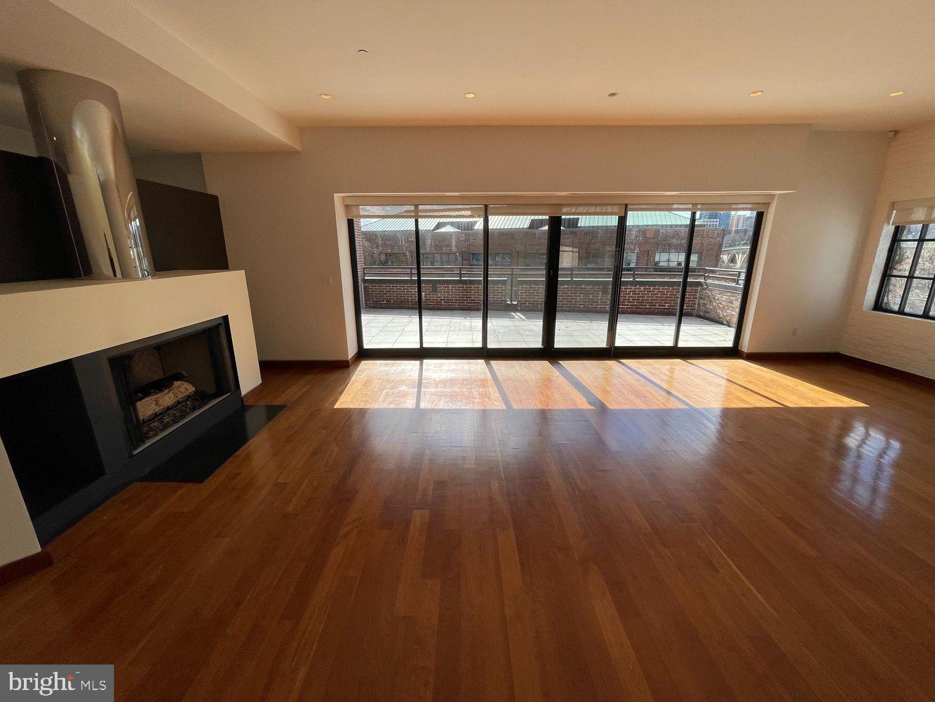3336 Cady's Alley Northwest, Unit 201 Washington, DC 20007 - Photo 5 of 34 a view of an empty room with wooden floor and a fireplace