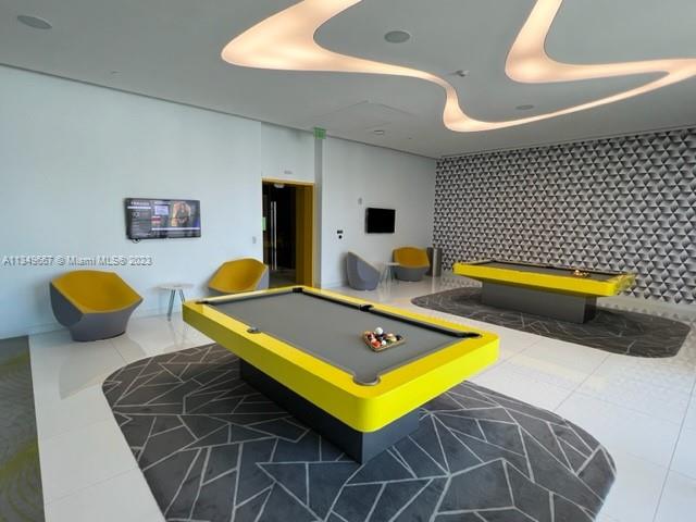 Edgewater Miami, FL 33137 - Photo 43 of 65 a living room with pool tables and a chandelier