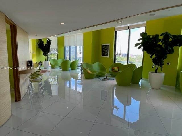 Edgewater Miami, FL 33137 - Photo 56 of 65 a living room with couches and potted plants with wooden floor