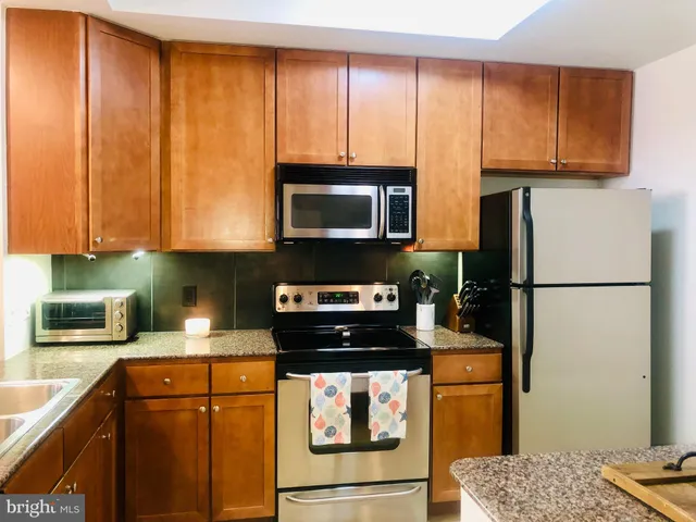 a kitchen with a refrigerator a stove a microwave and cabinets