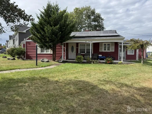 a view of a house with a yard and sitting area