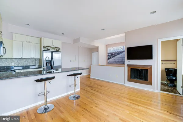 a kitchen with granite countertop a stove and a wooden floor