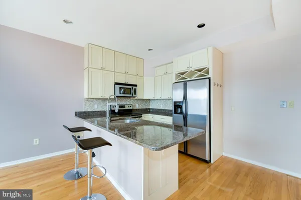 a kitchen with stainless steel appliances granite countertop a sink a stove a microwave a counter top space and cabinets