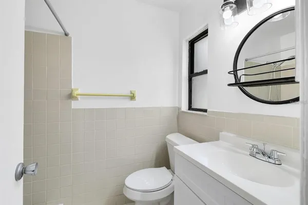 a bathroom with a sink a toilet and mirror