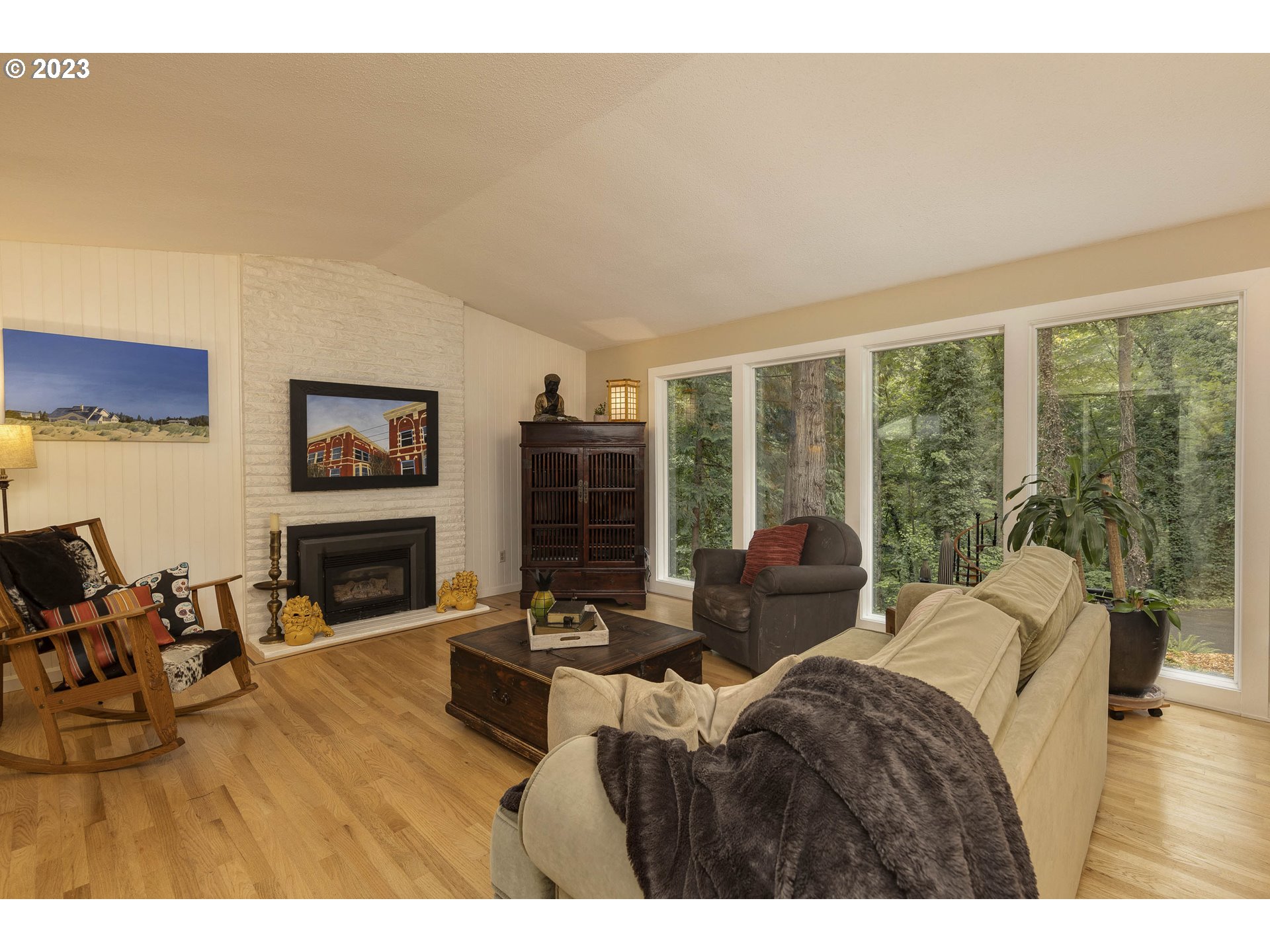 9732 Southwest 18th Place Portland, OR 97219 - Photo 11 of 45 a living room with furniture a fireplace and a floor to ceiling window