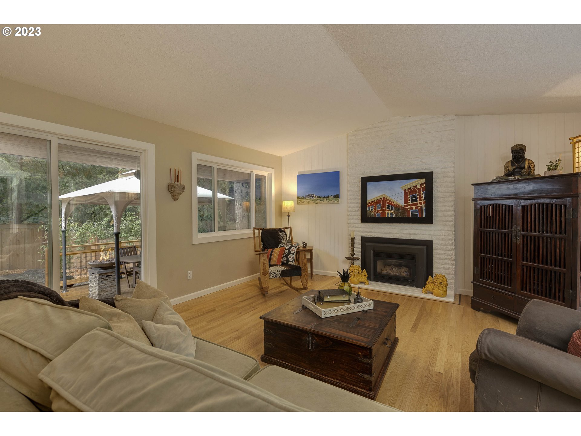 9732 Southwest 18th Place Portland, OR 97219 - Photo 13 of 45 a living room with furniture a flat screen tv and a fireplace