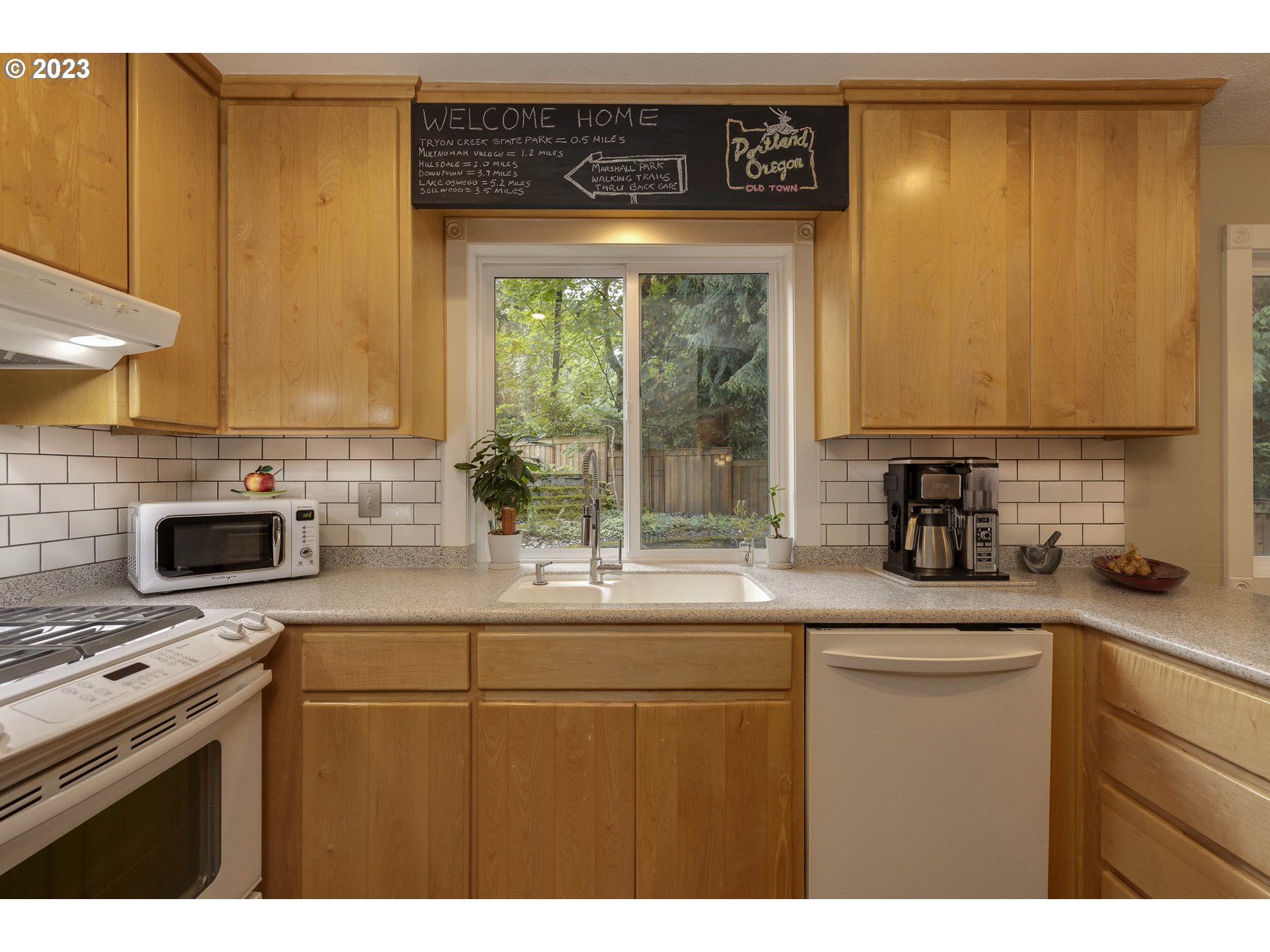 9732 Southwest 18th Place Portland, OR 97219 - Photo 17 of 45 a kitchen with stainless steel appliances a stove a sink and a microwave