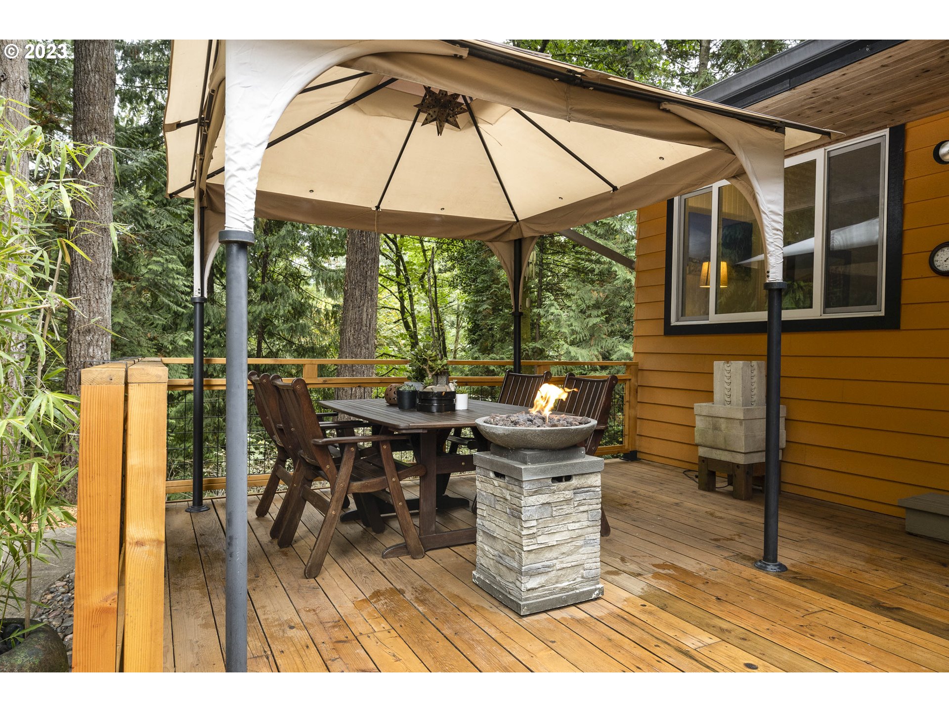 9732 Southwest 18th Place Portland, OR 97219 - Photo 30 of 45 a view of a patio with table and chairs under an umbrella