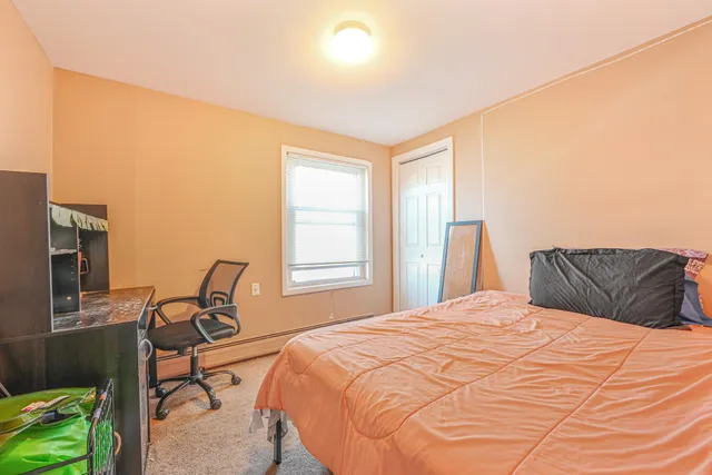 a bedroom with a bed chair and window