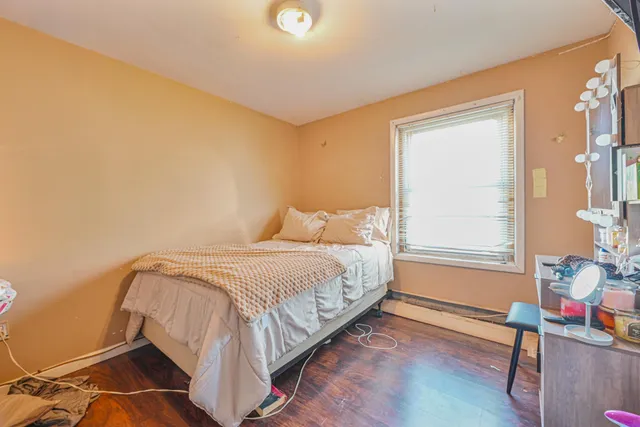 a bedroom with a bed and wooden floor